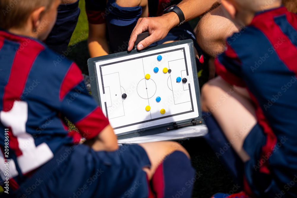 Foto de Football coach coaching kids using tactic strategy whiteboard. Soccer coach explaining