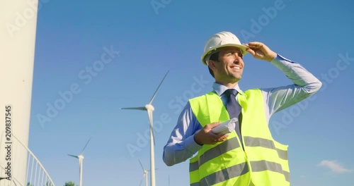 Wallpaper Mural Portrait an engineer controls the functioning of wind turbines that run thanks to the force of the wind and generate electricity sustainably to the planet. Concept of: renewable energy, Torontodigital.ca