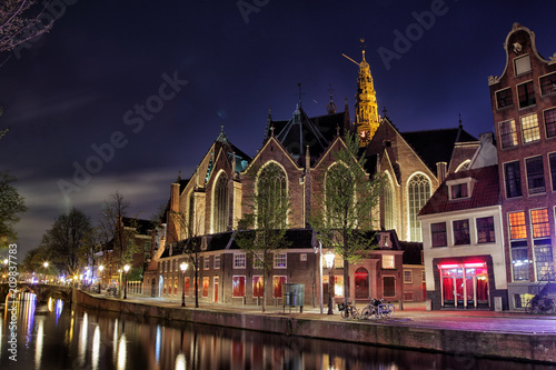 Nachtaufnahme der Oude Kerk, das älteste erhaltene Bauwerk in Amsterdam, Niederlande.