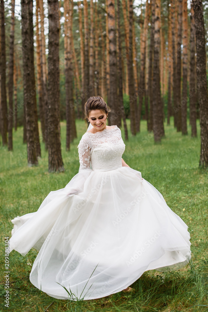 A beautiful bride in wedding dress is dancing alone outdoor