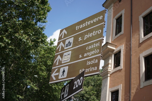 Italian signposts to Trastevere, Saint Peter cathedral, Castel Sant'Angelo, Tiber island and zoo