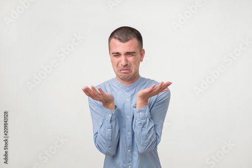 Εκτύπωση καμβά Studio shot of young handsome man, pouting and crying, complaining about girlfriend
