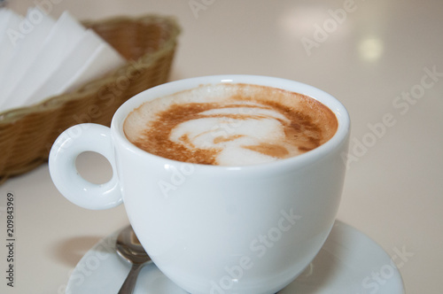 Appetizing coffee in a white cup on the table