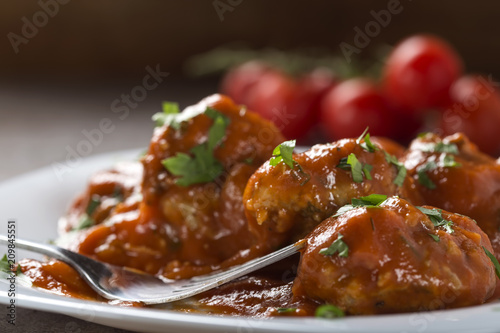 Meatballs with tomato sauce and fresh chopped parsley on plate