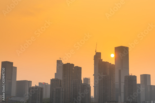 At sunset, the orange sky and the city buildings