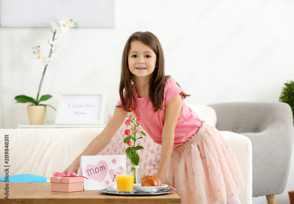 Little girl preparing surprise for her mommy on Mother's Day indoors