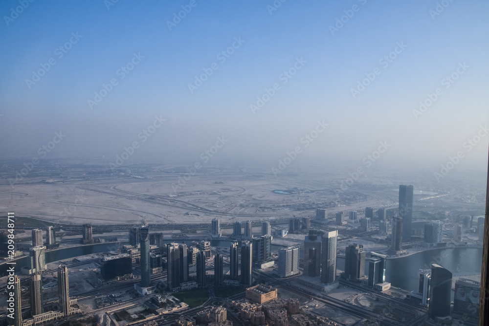 Dubai, United Arab Emirates -November 5, 2015: Aerial view of Downtown Dubai shooting through the glass window  from the tallest building in the world  , Burj Khalifa.