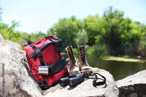Traveling gear on rock near river. Summer camp