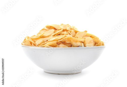Dried garlic flakes in bowl on white background