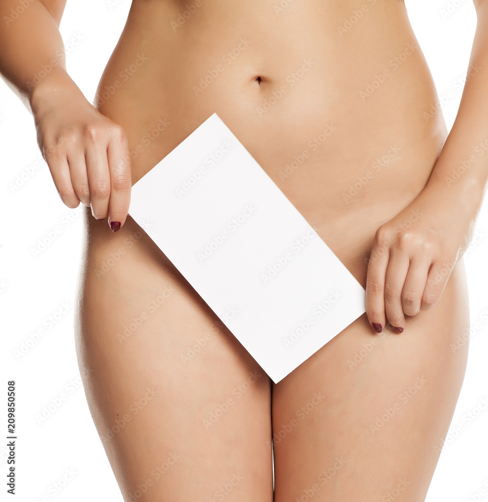 Naklejka premium Female covers her pubic area by white empty sign on white background