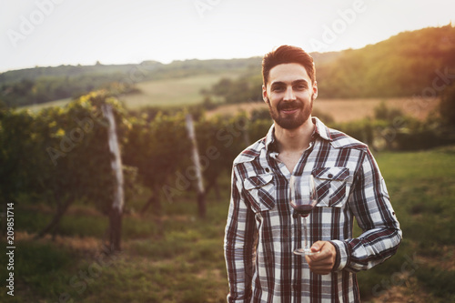 Winegrower tasting wine in vineyard