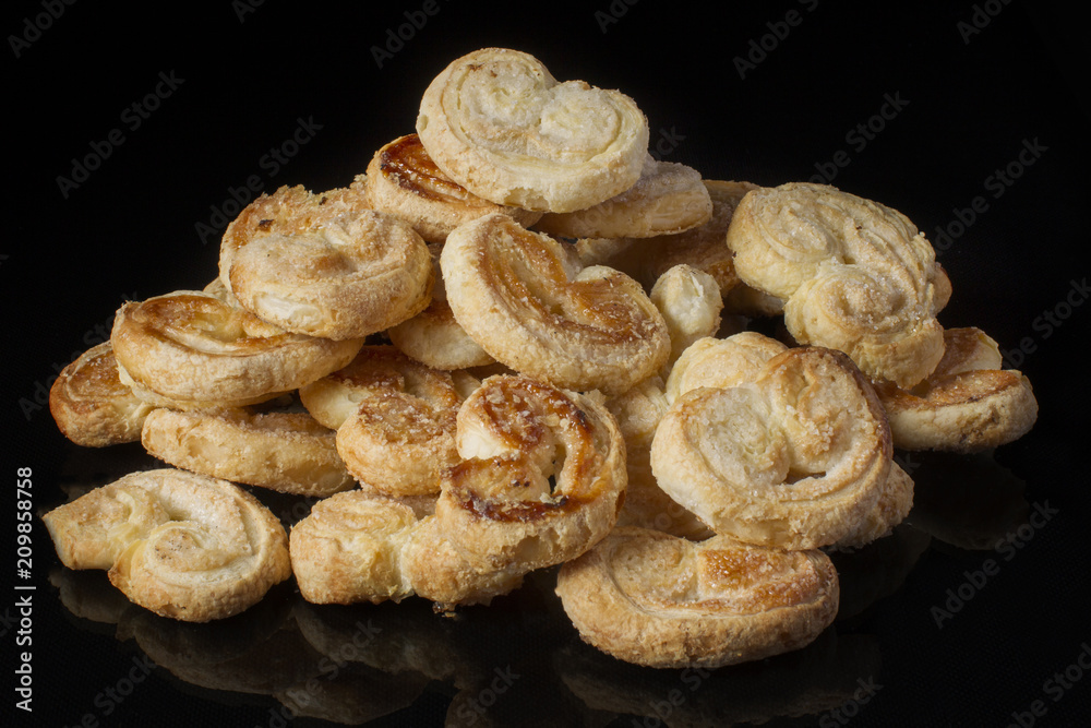 Cookies puff pastry ears on a dark background Cookies puff pastry ears on a dark background