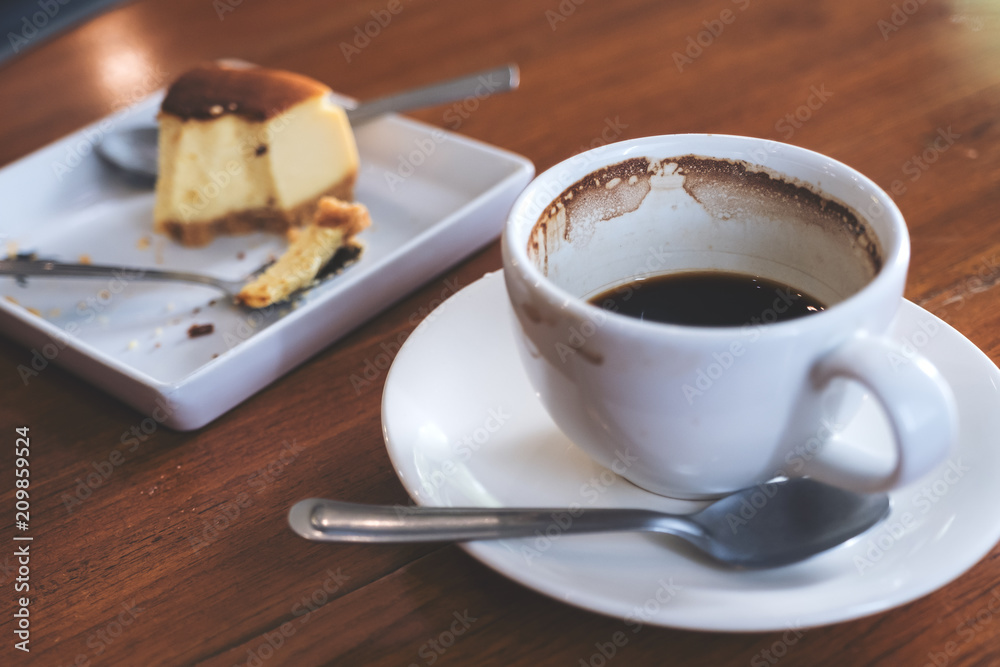 A cup of coffee and a piece of cake on table in cafe A cup of coffee and a piece of cake on table in cafe
