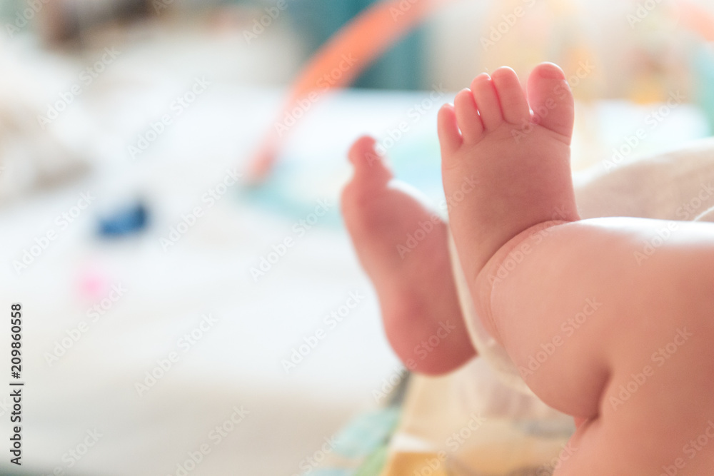 Naklejka premium The small tiny cute feet of the infant. Blurred light background.