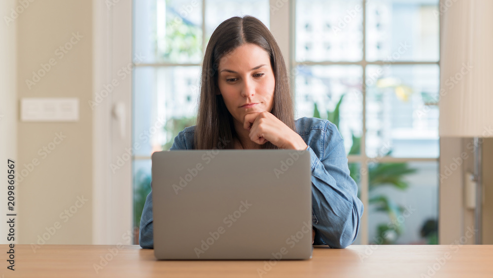 Young woman using laptop at home serious face thinking about question, very confused idea Young woman using laptop at home serious face thinking about question, very confused idea