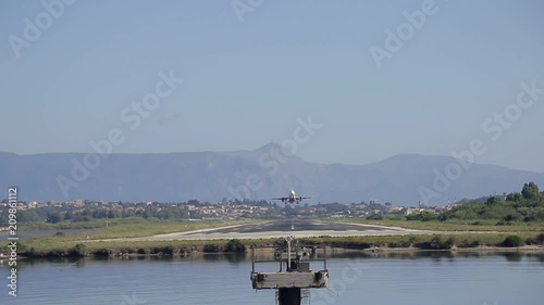 the plane approach and landing at Kerkira airport at summer day above the sea photo