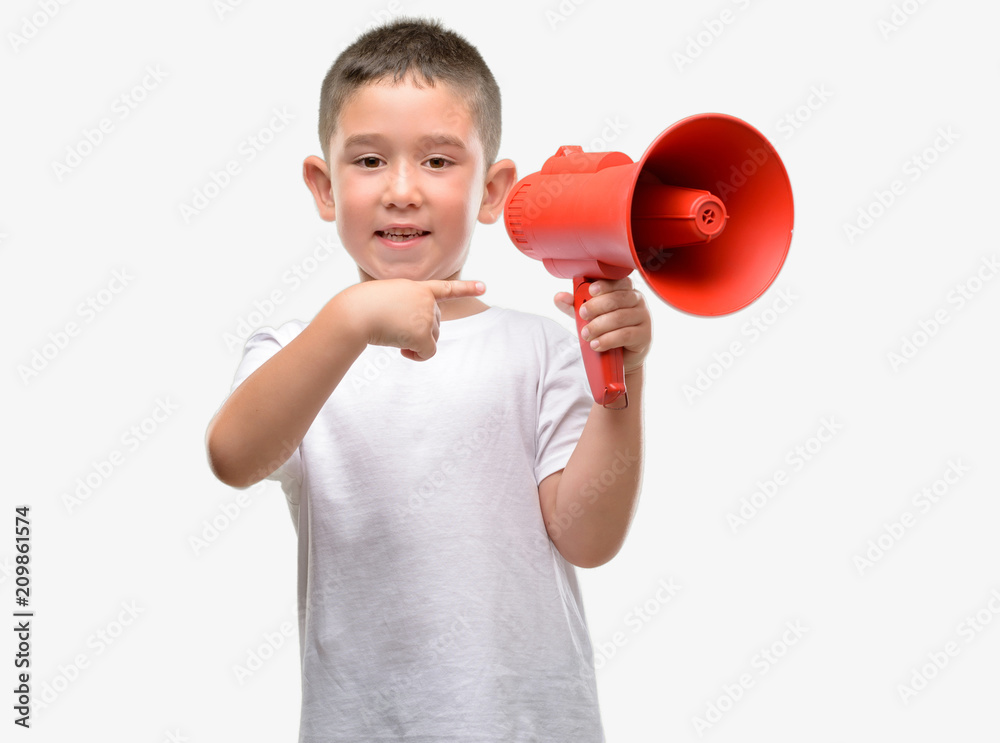 Dark haired little child holding megaphone very happy pointing with hand and finger Dark haired little child holding megaphone very happy pointing with hand and finger