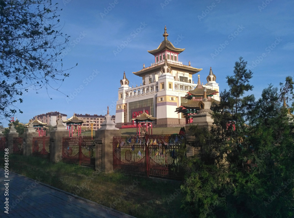 The big white Buddhist temple (The Golden Abode of the Buddha Shakyamuni) in Elista, the capital of the Republic of Kalmykia. It is sunny. The sky is blue and clear. 