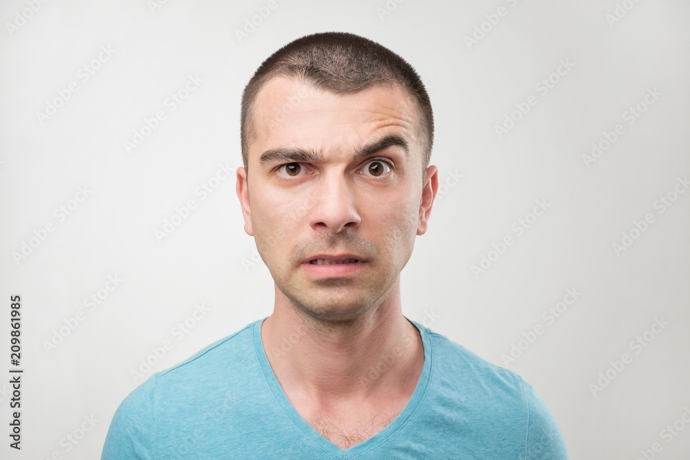 Close up portrait of latin serious man with strict expression looks directly into camera raises eyebrow. Close up portrait of latin serious man with strict expression looks directly into camera raises eyebrow.