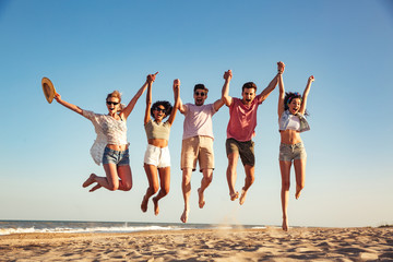 Group of happy young friends dressed in summer clothes