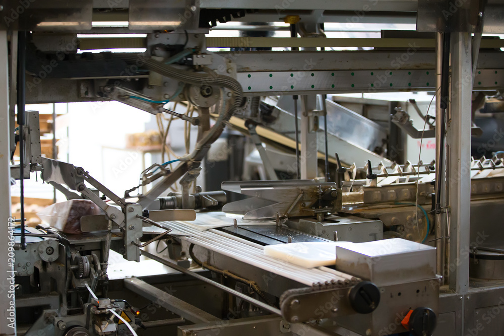 Industrial line for packaging of bakery products. Packing of bread at the factory.The machine for cutting and packing in a factory for the production of bread.