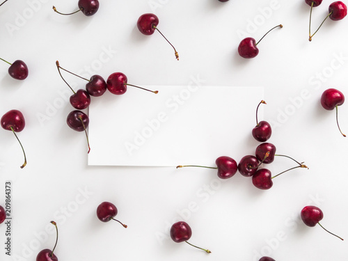 Creative layout with fresh ripe berries. Cherry isolated on white background with white rectangle for copy space. Can use for your design, promo, social media. Top view