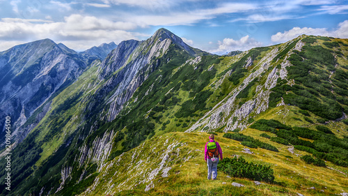 Landscape south side view of mountain peak Sija and one alpinist walking to the top. Summer in Julian Alps, Bohinj, Slovenia, Europe. photo