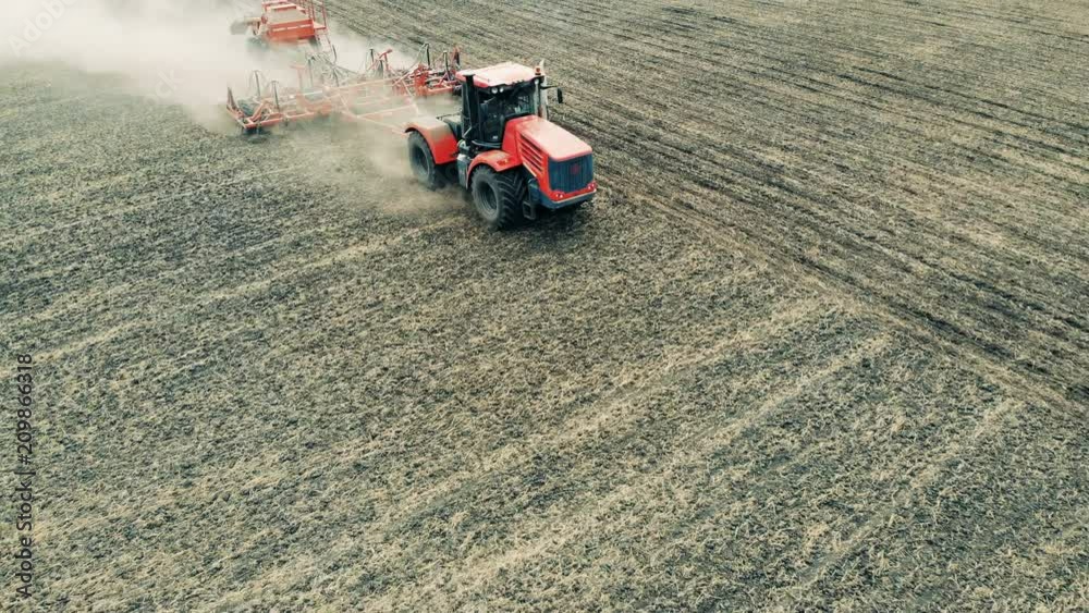 The tractor moves across the field. Aerial, top view. The tractor moves across the field. Aerial, top view.