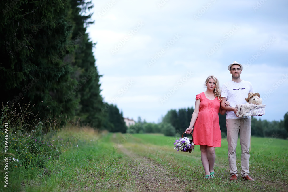 Obraz premium Pregnant girl with big belly and young man outdoor
