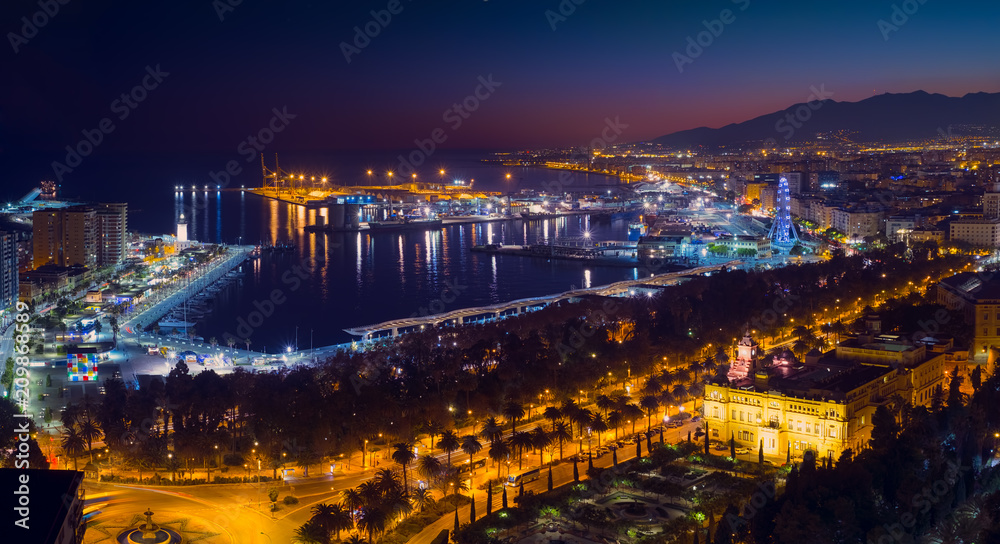 Malaga city with seafront and harbor in the night