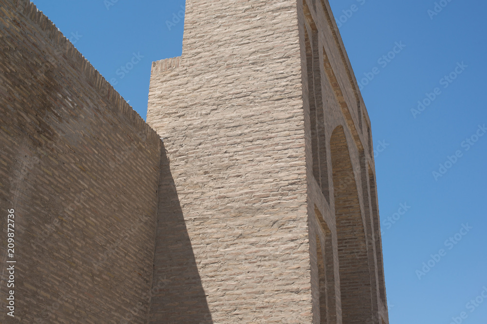 An old brick building with a tower. Ancient buildings of medieval Asia. Bukhara, Uzbekistan
