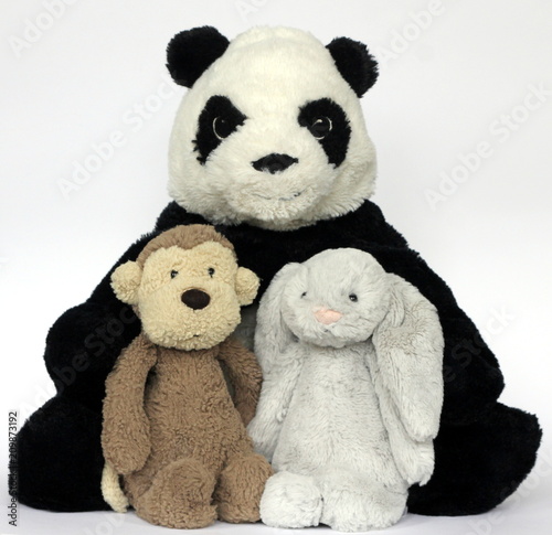 A plush and fluffy soft toy panda, monkey and rabbit on a white background