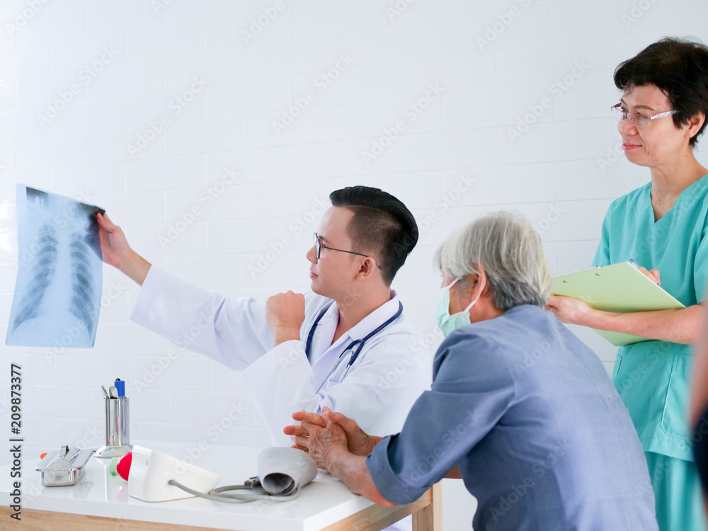Doctor holding x-ray film in hands present to elderly woman in hospital .Health care concept. Doctor holding x-ray film in hands present to elderly woman in hospital .Health care concept.