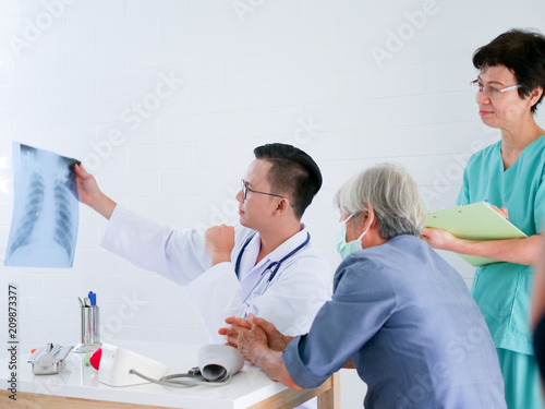 Doctor holding x-ray film in hands present to elderly woman in hospital .Health care concept.