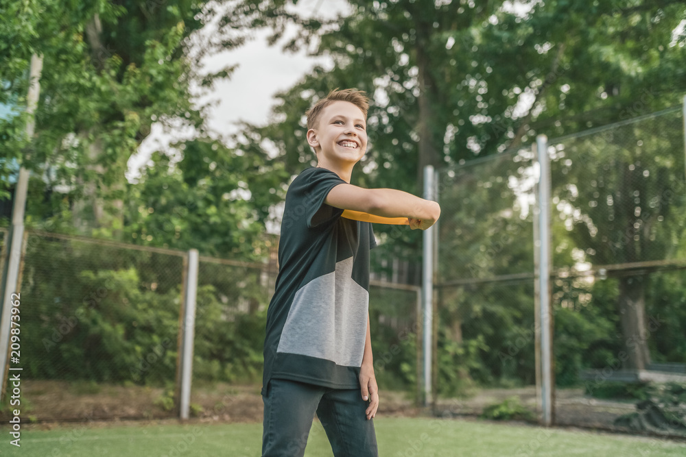 beautiful smiling boy playing with flying disc and looking away outdoors beautiful smiling boy playing with flying disc and looking away outdoors