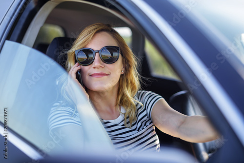 Woman speaks on the phone in the car. © Denis Rozhnovsky