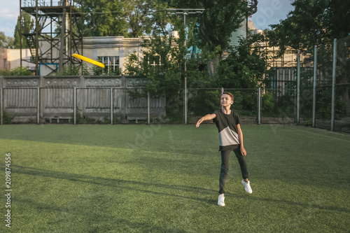 full length view of boy throwing flying disc on green lawn © LIGHTFIELD STUDIOS