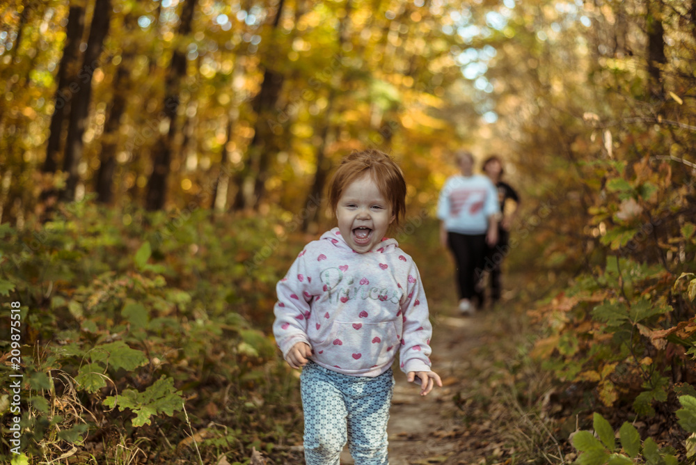 happy little child, baby girl laughing and playing in autumn park