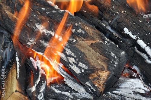 Burning fire in a rustic grill with firewood, close up