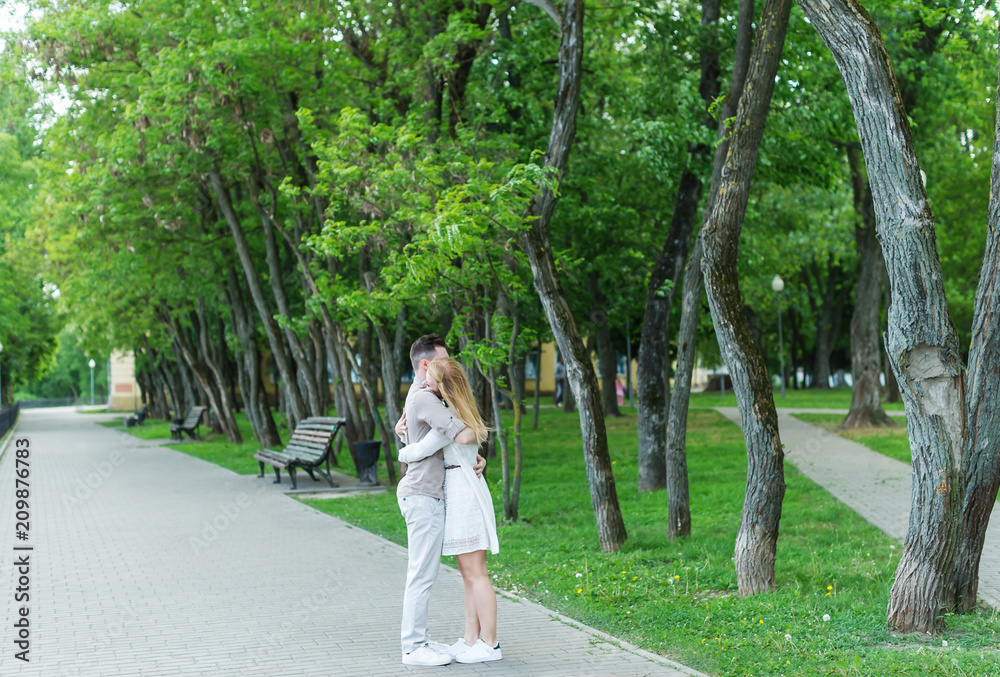 Gentle embraces of young couple in the city park. Beautiful couple perfectly spends time outdoors. Gentle embraces of young couple in the city park. Beautiful couple perfectly spends time outdoors.