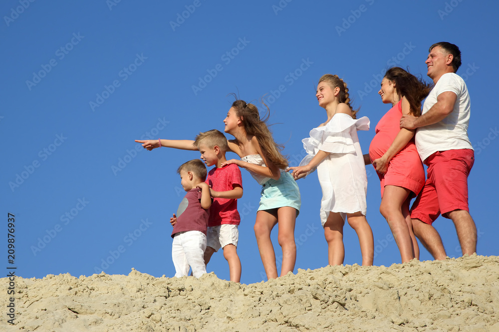 family with children standing together on a sandy hill family with children standing together on a sandy hill