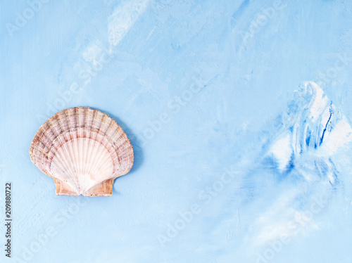Single big seashell on blue stone background  scallop shell  copy space. Minimalistic summer concept of holiday by sea