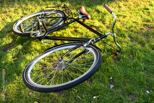 close up view of retro bicycle lying on green grass in park