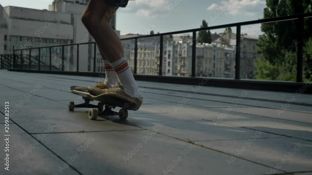 Young man skateboarder doing skateboard trick in daytime in summer, sport concept, urban concept