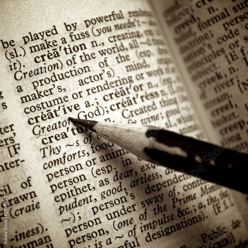 Black pencil point on creative word on old dictionary