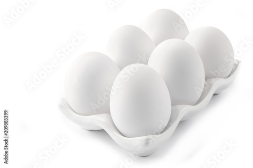 Six Large White Eggs on a White Ceramic Dish