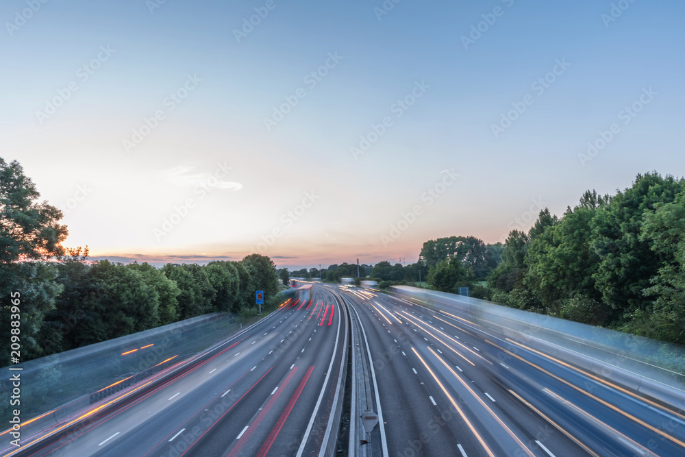 Sunset view heavy traffic moving at speed on UK motorway in England