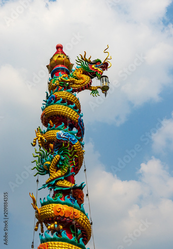 chinese golden dragon on red pillar with blue sky and cloud