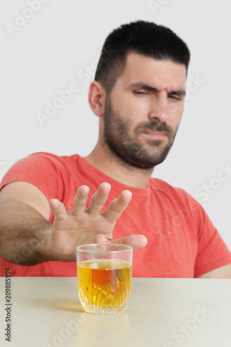 Studio portrait of young man refuses to drink - Man saying no to alcohol