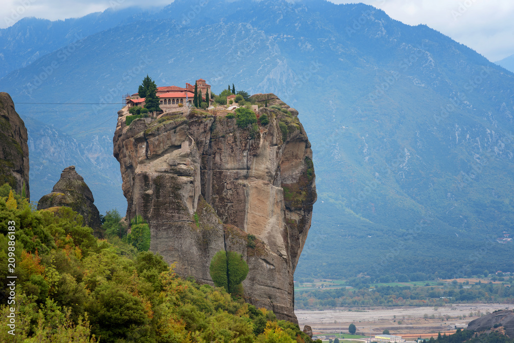 Magnificent autumn landscape. Monastery Holy Trinity, Meteora, Greece. UNESCO world heritage Site. Epic landscape with temple at the edge of cliff at dramatic sky background.